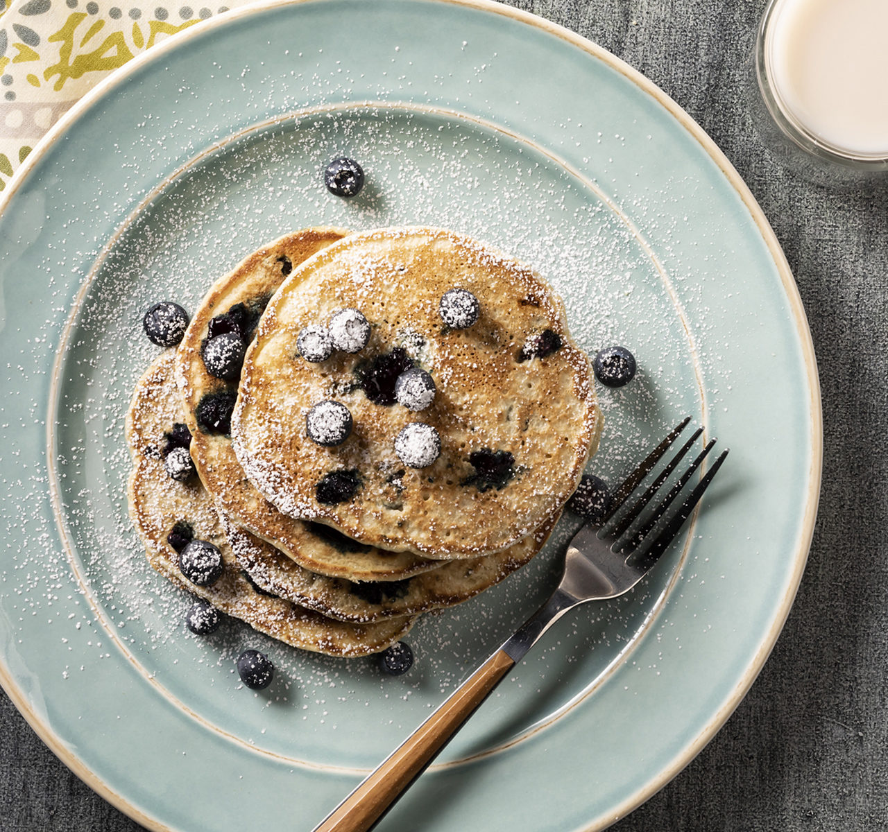 plate of vegan blueberry pancakes with powdered sugar